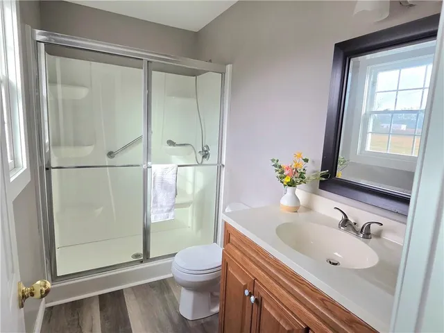 a bathroom with a sink a toilet and shower