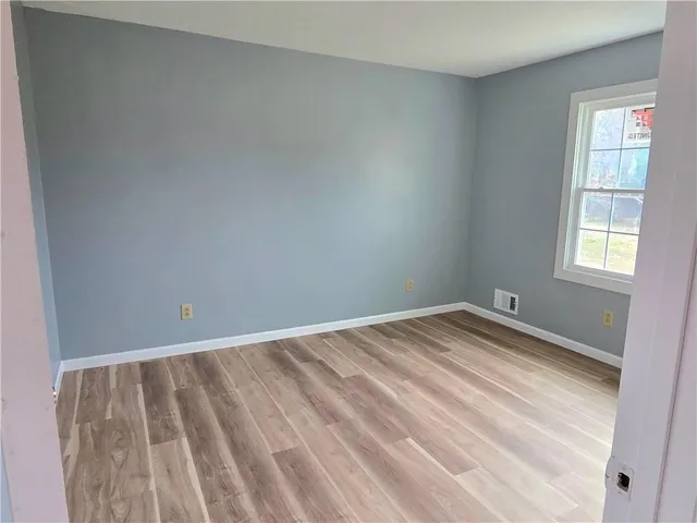 a view of a room with wooden floor and window