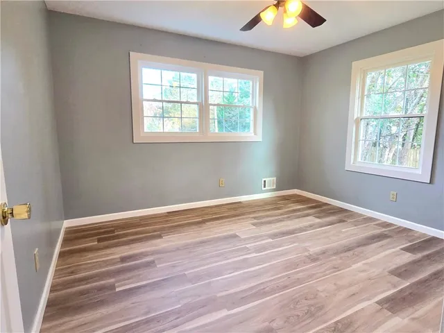 a view of a bedroom with wooden floor and a window
