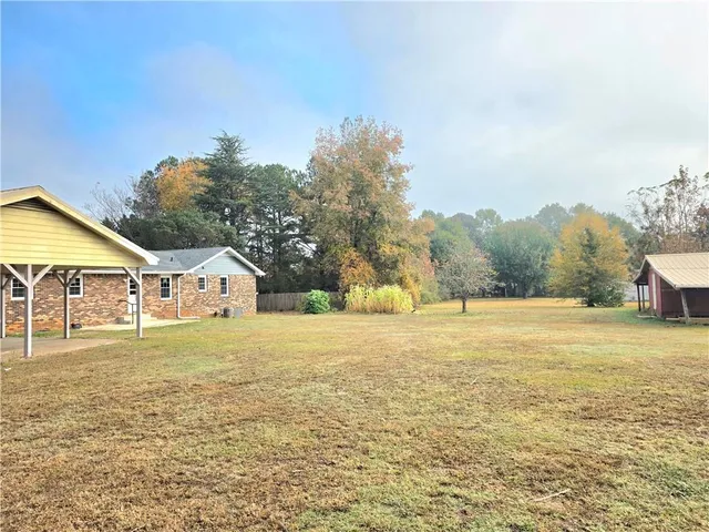 a view of a house with a yard and mountain view in back
