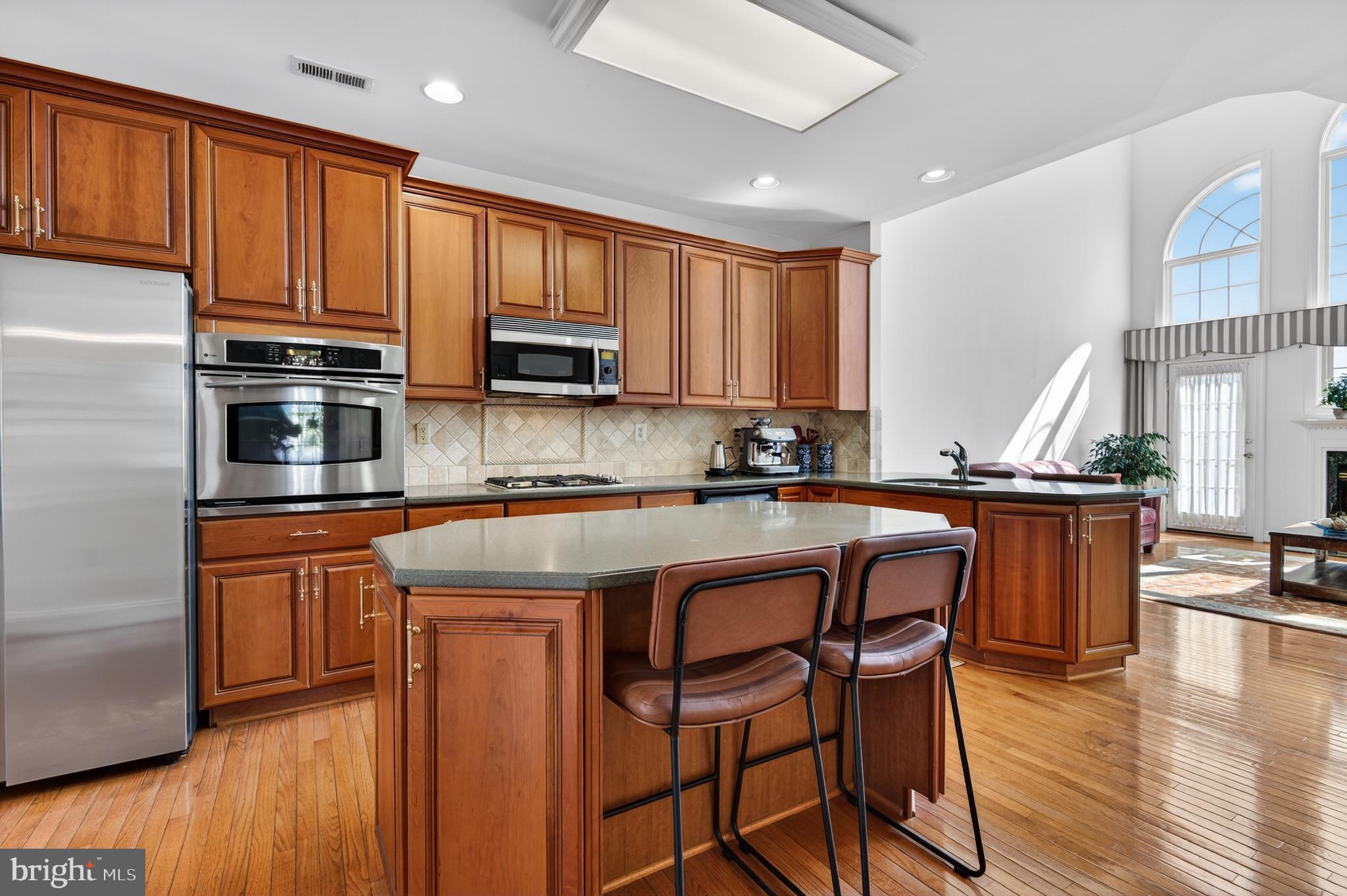98 Granville Way Exton, PA 19341 - Photo 13 of 35 a kitchen with stainless steel appliances granite countertop wooden cabinets a stove top oven a sink and dishwasher with wooden floor