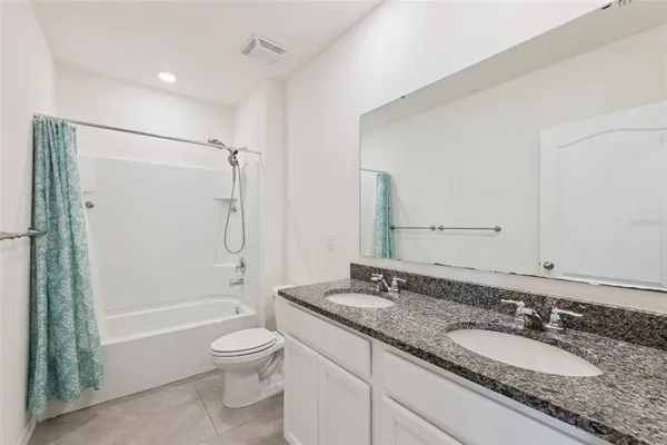 a bathroom with a granite countertop sink a mirror and a shower