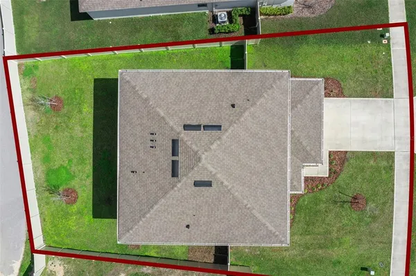 an aerial view of residential houses with outdoor space and trees