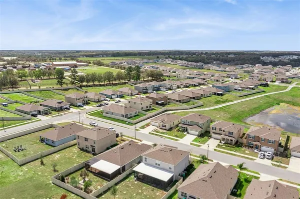 an aerial view of residential houses with outdoor space and ocean view
