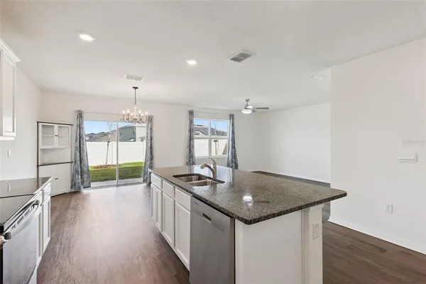 a kitchen that has a sink a stove and wooden floor