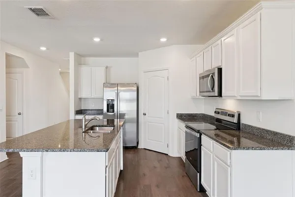 a kitchen with stainless steel appliances granite countertop a sink stove and refrigerator