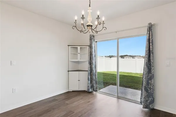 a view of a room with wooden floor fan and windows