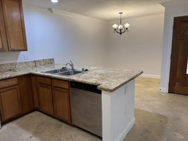 a kitchen with granite countertop a sink and a refrigerator