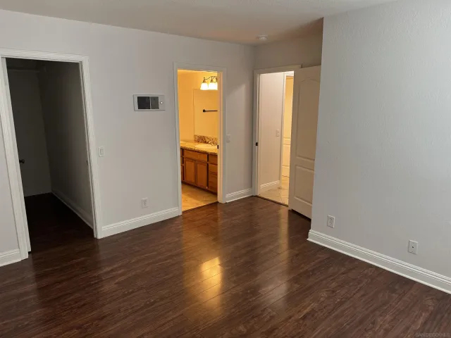 an empty room with wooden floor and closet