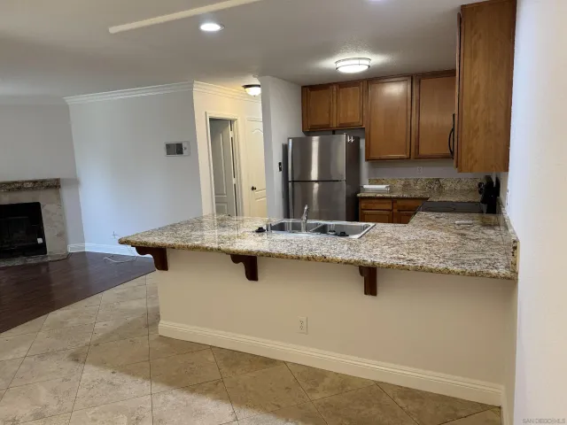 a kitchen with kitchen island granite countertop a sink and a stove