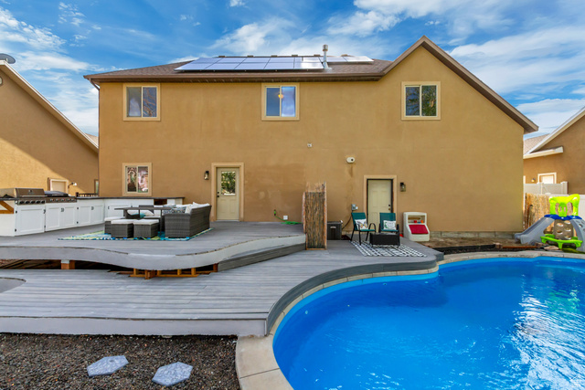 1585 South 910 West Payson, UT 84651 - Photo 24 of 32 Expansive backyard featuring a large in-ground swimming pool, a multi-level wood-finish deck, and an outdoor kitchen with built-in cabinetry and grill