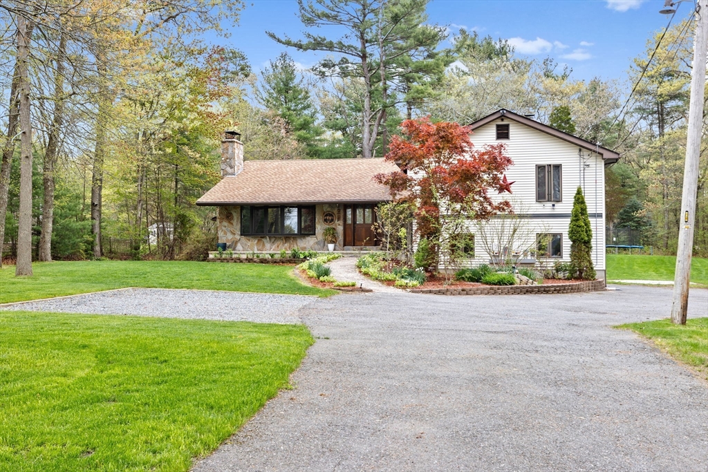 a view of a house with a yard and sitting area