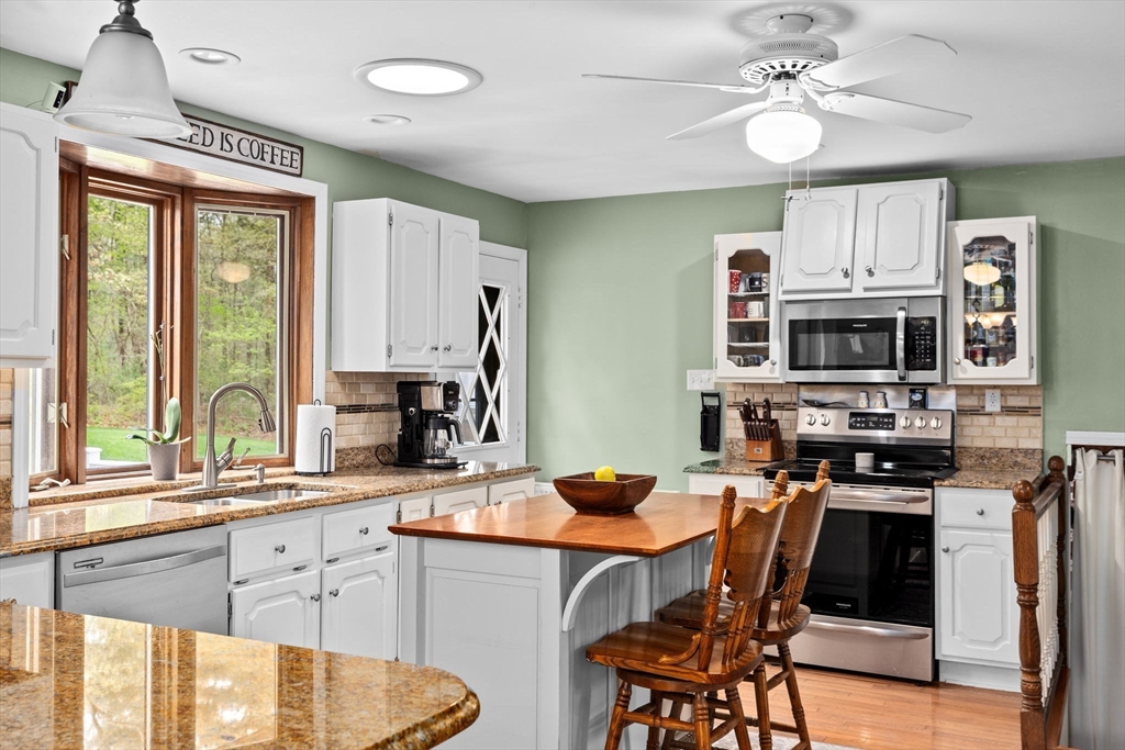 39 High Street Freetown, MA 02702 - Photo 11 of 42 a kitchen with stainless steel appliances granite countertop a stove a sink dishwasher a refrigerator with a dining table and chairs