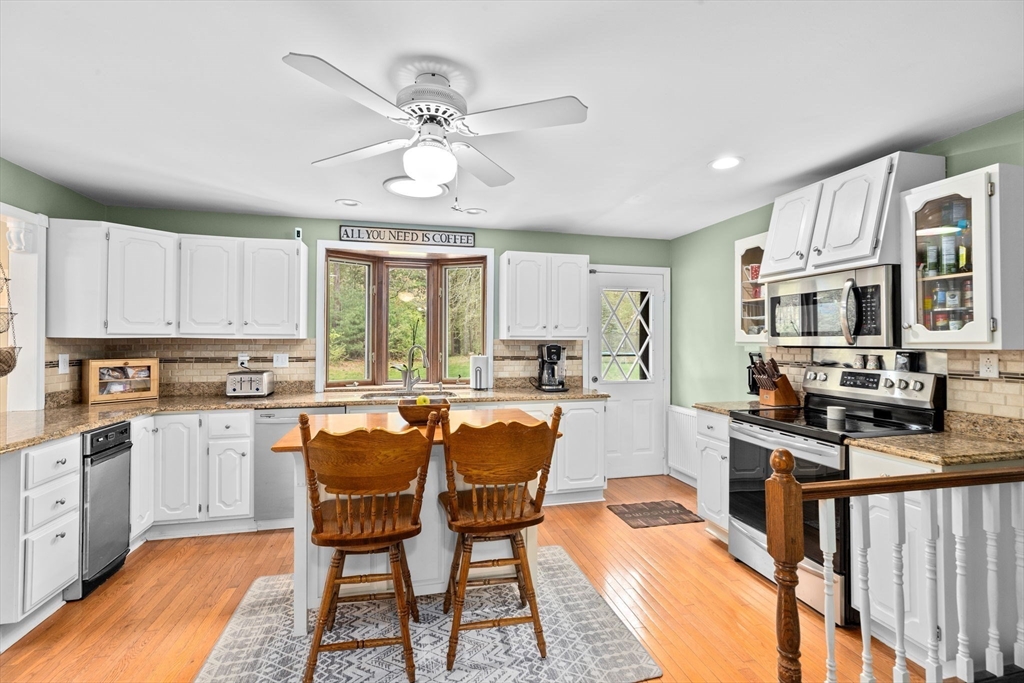 39 High Street Freetown, MA 02702 - Photo 12 of 42 a kitchen with stainless steel appliances granite countertop a stove top oven a sink dishwasher a dining table and chairs with wooden floor