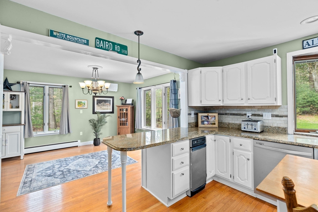 39 High Street Freetown, MA 02702 - Photo 13 of 42 a kitchen with granite countertop a stove a sink dishwasher and white cabinets with wooden floor