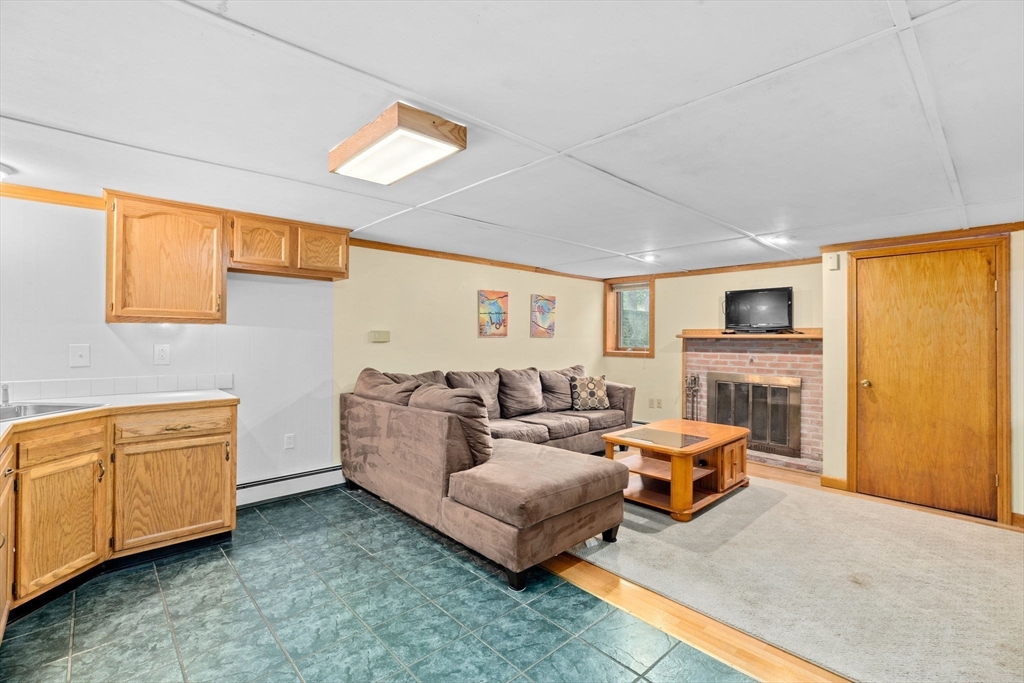 39 High Street Freetown, MA 02702 - Photo 25 of 42 a living room with furniture a fireplace and a flat screen tv