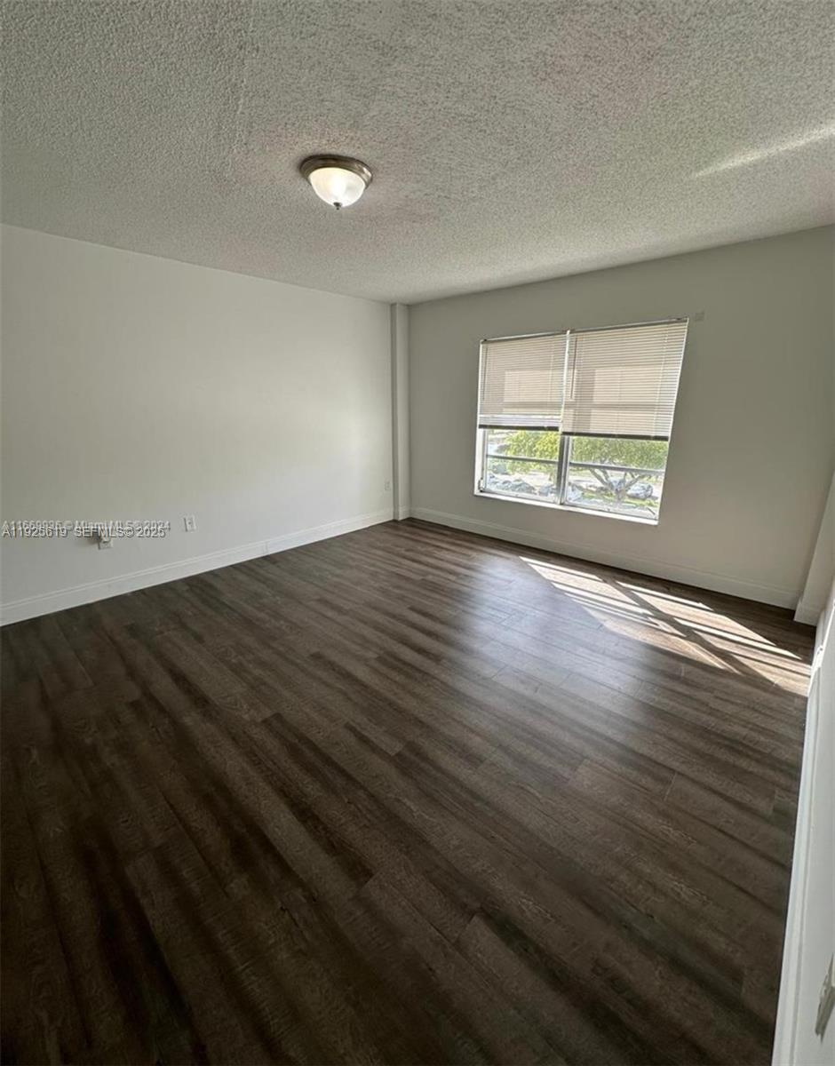4164 Inverrary Drive, Unit 406 Lauderhill, FL 33319 - Photo 13 of 13 an empty room with wooden floor and windows