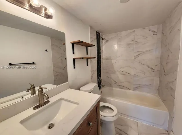 a bathroom with a sink a toilet and bathtub