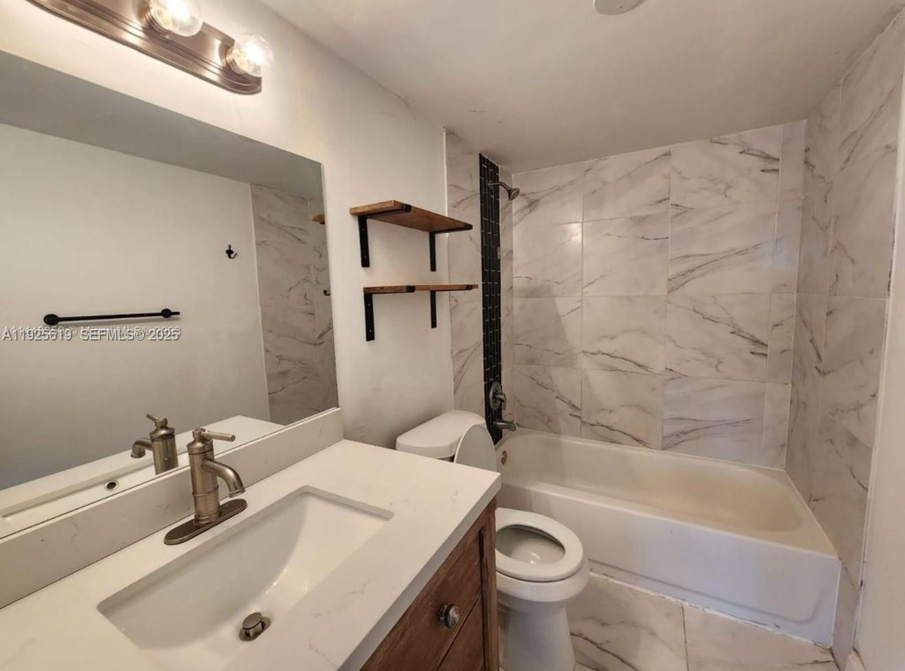 4164 Inverrary Drive, Unit 406 Lauderhill, FL 33319 - Photo 5 of 13 a bathroom with a sink a toilet and bathtub