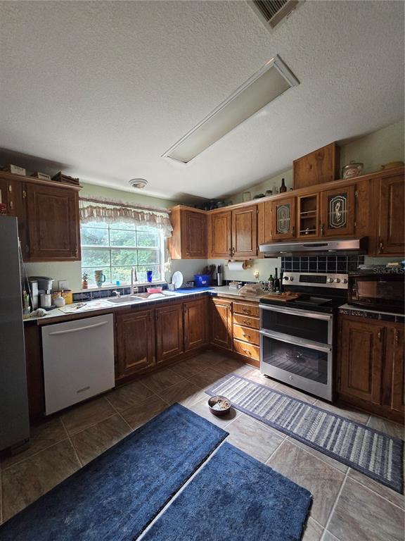 4901 Northwest 152nd Lane Reddick, FL 32686 - Photo 12 of 13 a kitchen with stainless steel appliances kitchen island granite countertop a stove and a sink