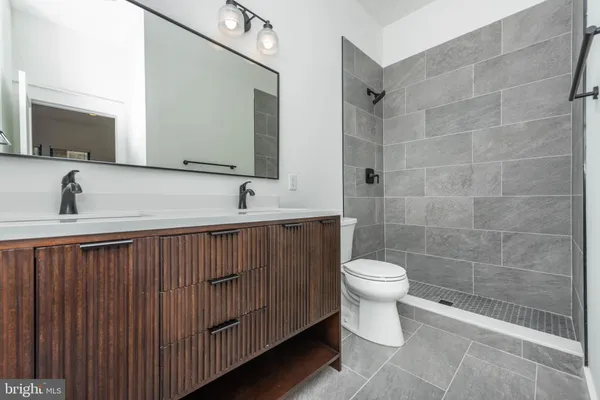 a bathroom with a sink a toilet and a mirror