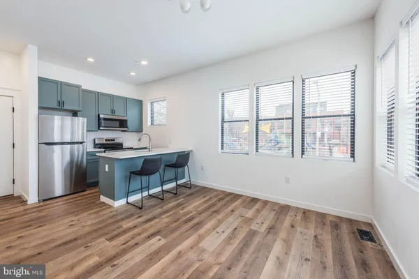 a kitchen with a refrigerator and a stove top oven