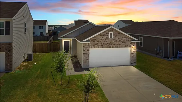 a view of a grey house with a yard