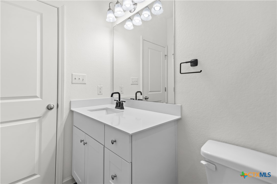 430 Line Of Fire Way Jarrell, TX 76537 - Photo 19 of 28 a bathroom with a toilet a sink and mirror