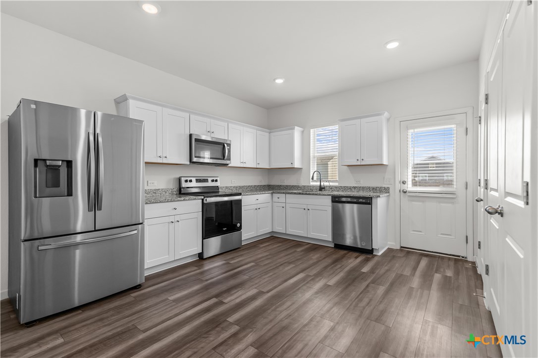 430 Line Of Fire Way Jarrell, TX 76537 - Photo 9 of 28 a kitchen with white cabinets stainless steel appliances and a window