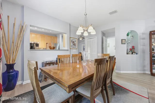 a dining room with furniture a chandelier and wooden floor
