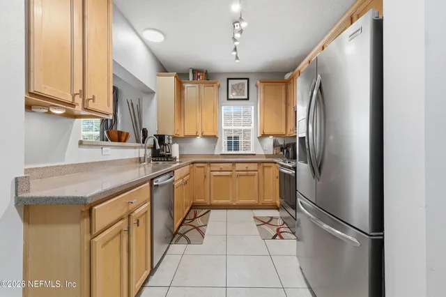 a kitchen with a refrigerator a sink and cabinets
