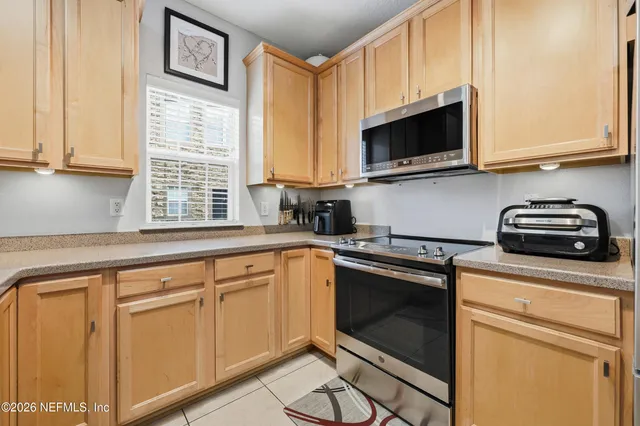 a kitchen with kitchen island granite countertop a sink cabinets and appliances