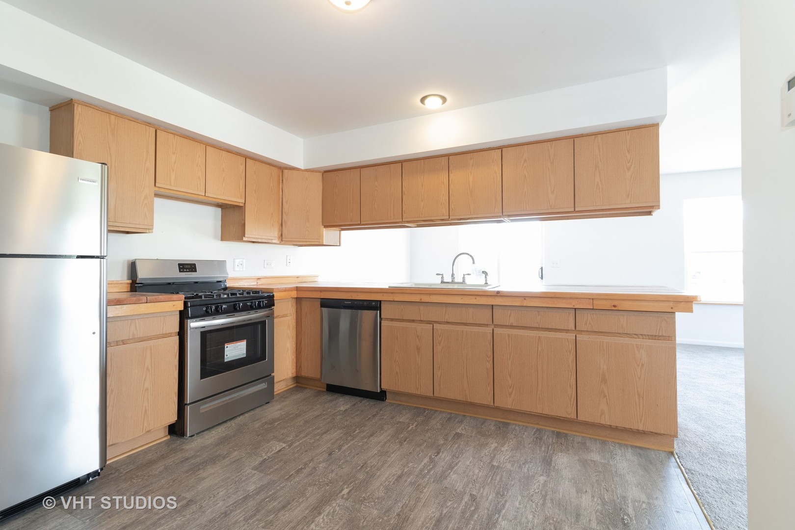 25188 Faraday Road Manhattan, IL 60442 - Photo 5 of 10 a kitchen with granite countertop a sink stove a refrigerator a microwave and cabinets