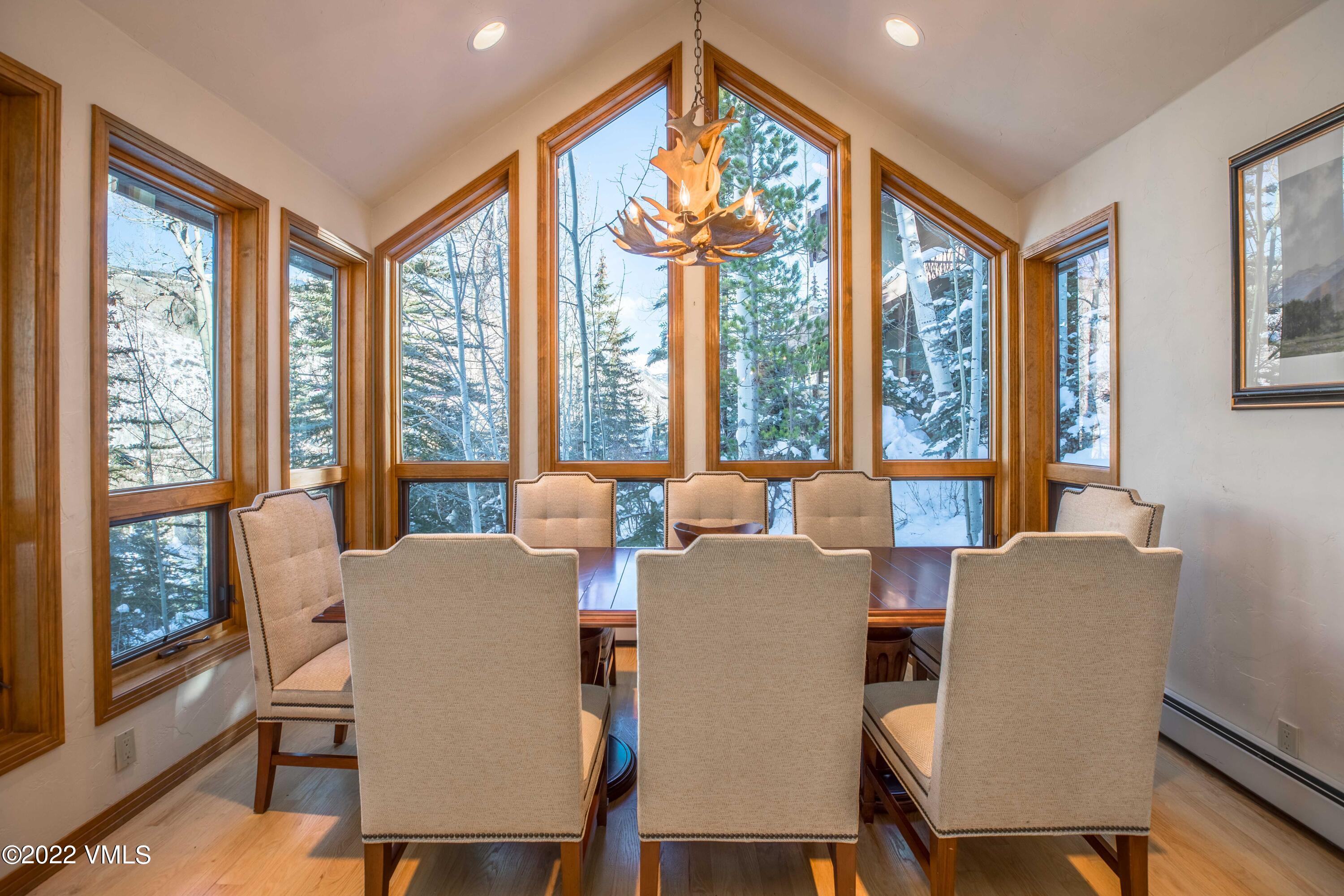 224 West Forest Road Vail, CO 81657 - Photo 5 of 12 a view of a dining room with furniture large windows and wooden floor