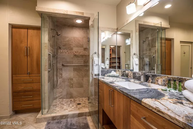 a bathroom with a granite countertop sink mirror and shower