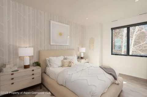 a bedroom with a bed and a large window