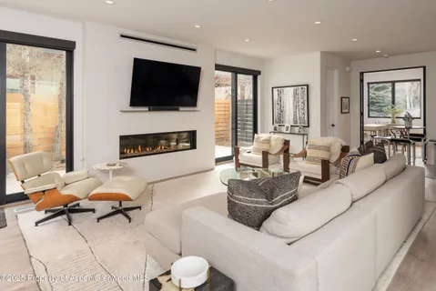 a living room with furniture a flat screen tv and a fireplace