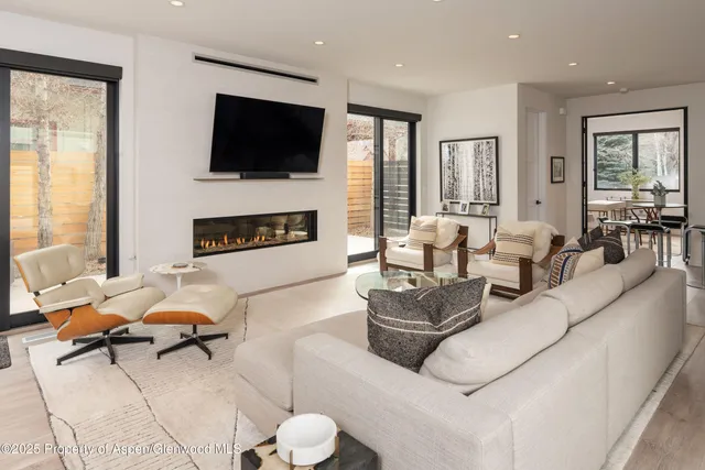 a living room with furniture a flat screen tv and a fireplace