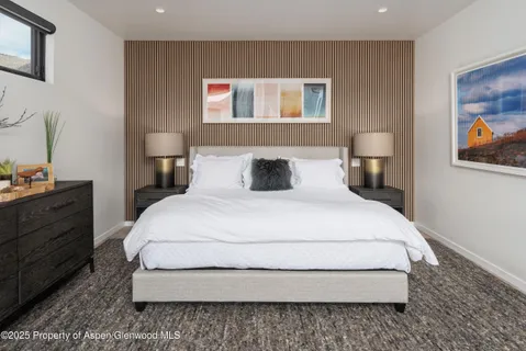 a bedroom with a bed and painting on the wall