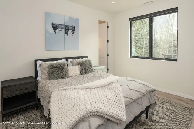 a bedroom with a bed and painting on the wall