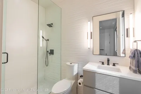 a bathroom with a sink vanity granite toilet and shower