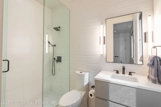 a bathroom with a sink vanity granite toilet and shower