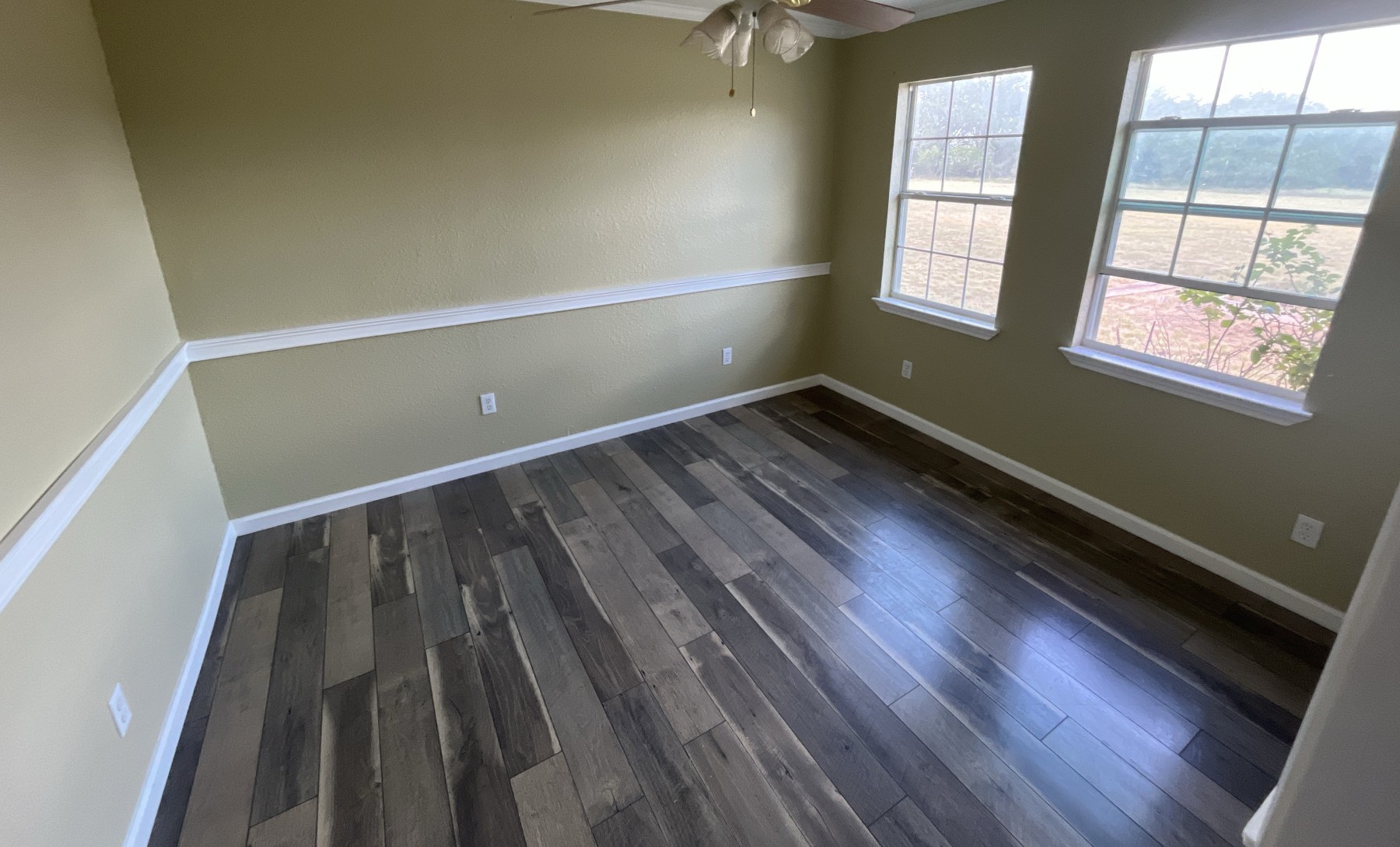 524 Rangeland Road Blanco, TX 78606 - Photo 9 of 23 Well-lit room featuring durable wood flooring and ample natural illumination from multiple windows.