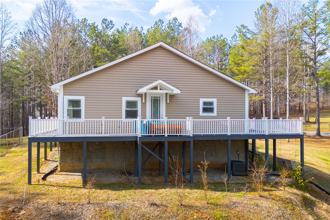 This elevated home with a spacious deck offers serene views of the surrounding natural landscape.