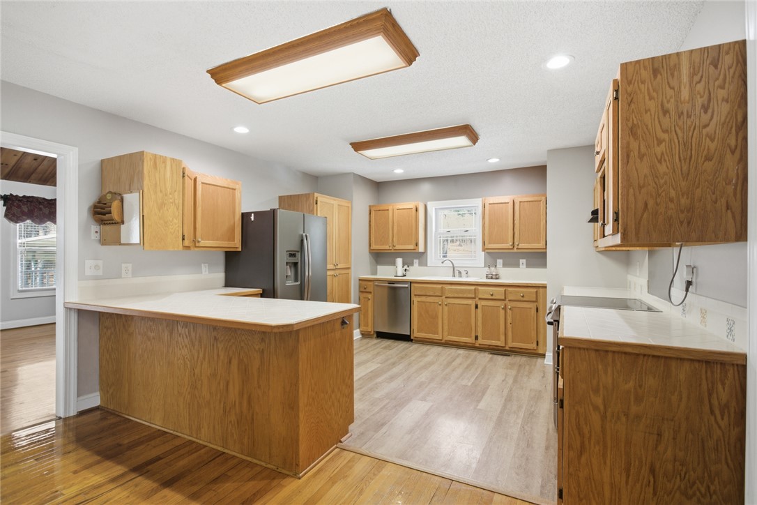 196 Flyroot Trail Pickens, SC 29671 - Photo 10 of 48 This bright kitchen features wood cabinetry and essential appliances for daily living.