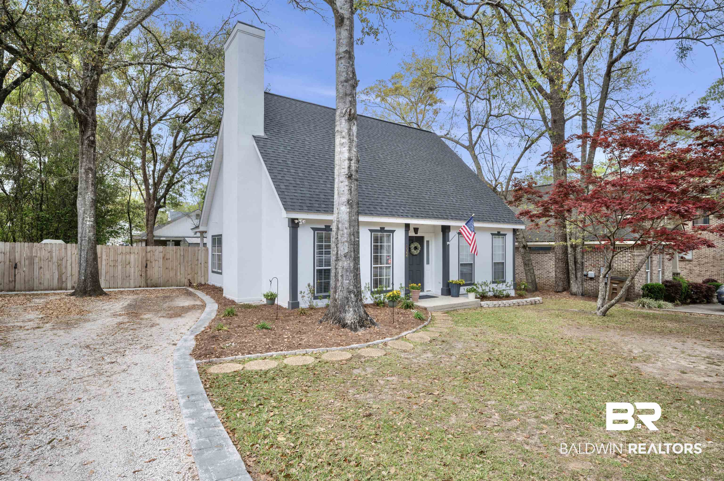 1066 Linlen Avenue Mobile, AL 36609 - Photo 3 of 22 View of front of property with stucco siding, fence, roof with shingles, a front yard, and a chimney