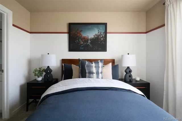 a bed sitting in a bedroom and painting on the wall