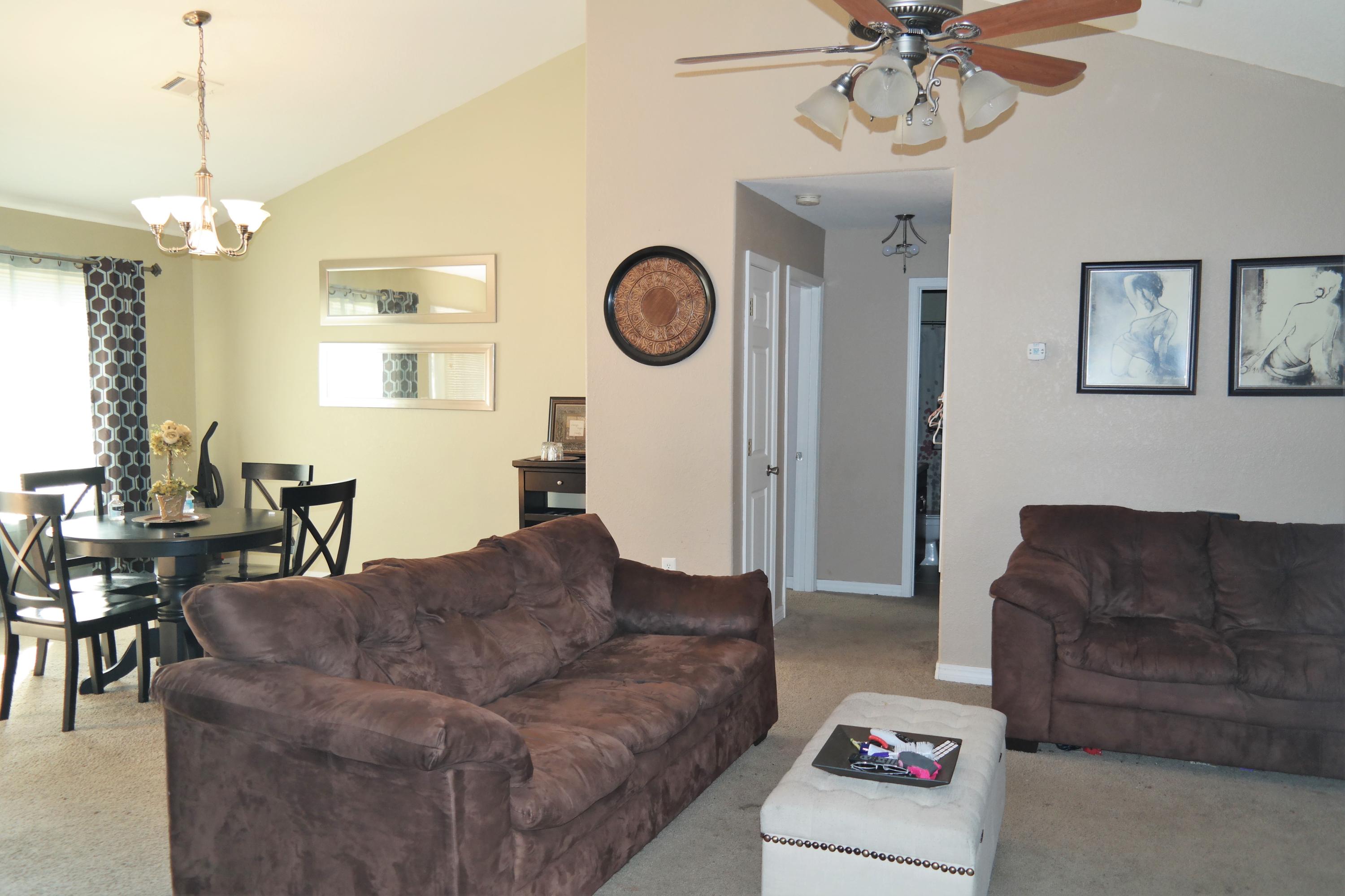 130 Crocus Avenue DeFuniak Springs, FL 32433 - Photo 3 of 24 a living room with furniture a dining table and a chandelier