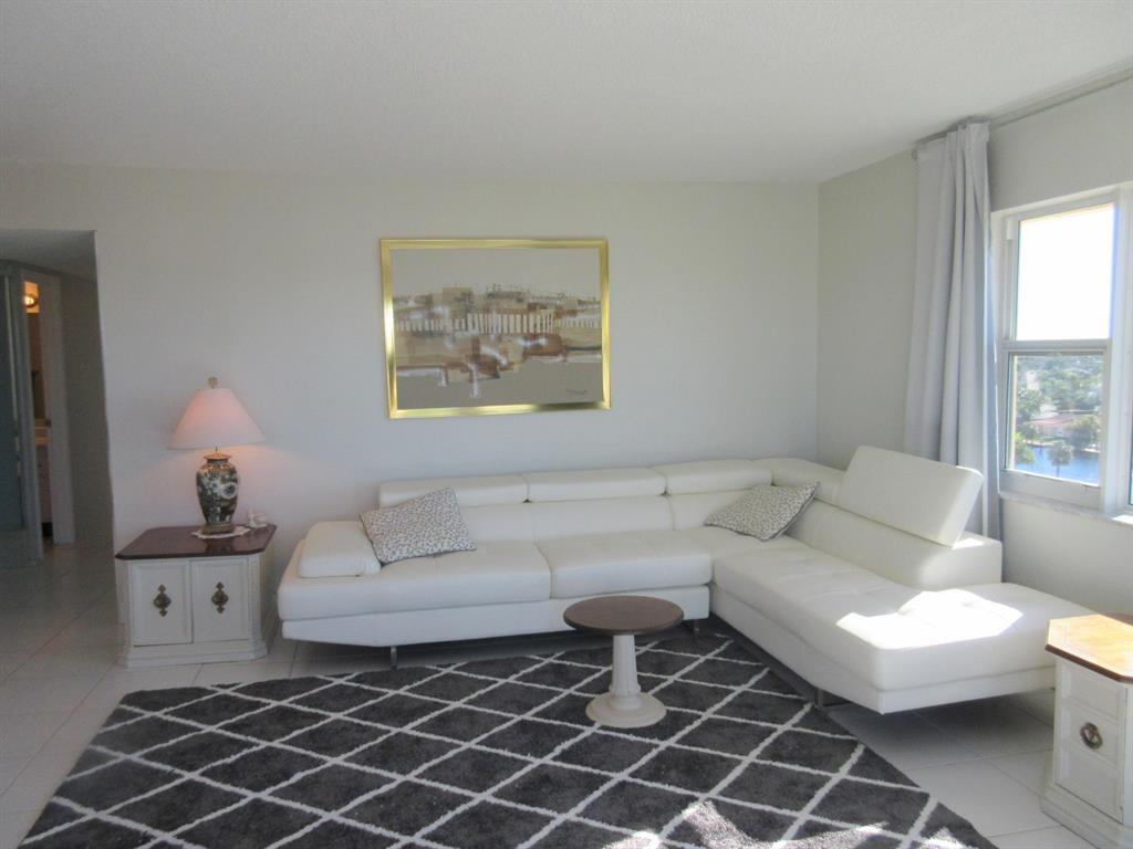 1200 Hibiscus Avenue, Unit 801 Pompano Beach, FL 33062 - Photo 2 of 12 a living room with furniture a lamp and a window