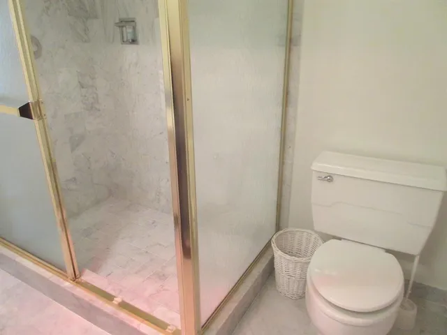 a white toilet sitting next to a bath tub